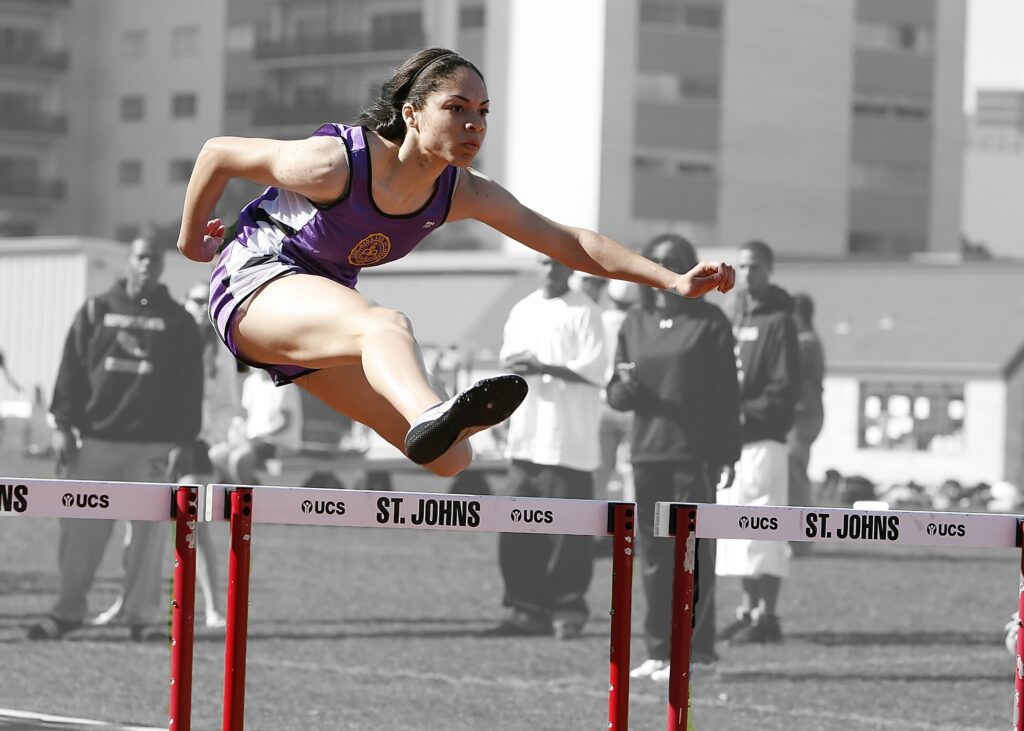 Woman running and jumping a hurdle